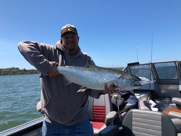 Chris Carson holding a salmon on a boat